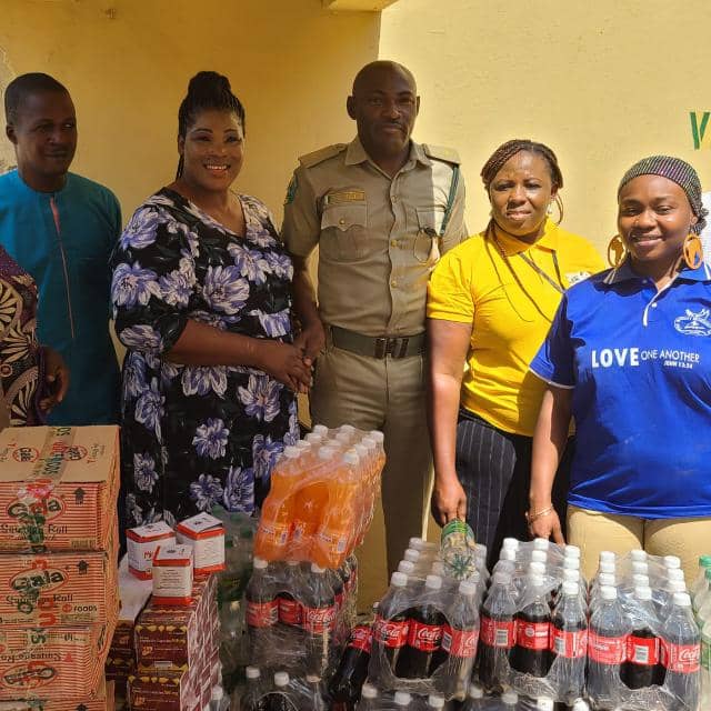 Foundation team with correctional officer and donated supplies at Suleja Custodial Centre including noodles, water, and refreshments
